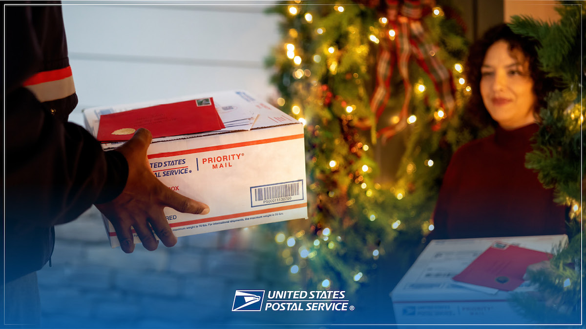 A photo of a postal carrier holding package and mails delivers to a woman customer with the USPS logo overlayed.