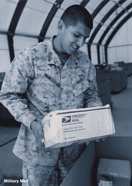 soldier in fatigues looking at a priority mail large flate rate box