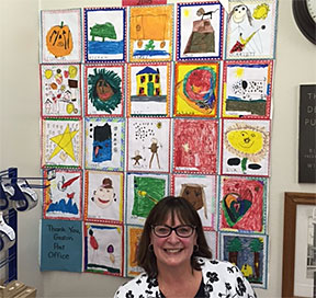 Rosellen Simmons in front of a display from Ms. Drury’s kindergarten class Rosellen Simmons in front of a display from Ms. Drury’s kindergarten class