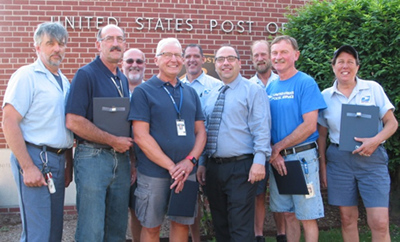 Letter Carrier Andre Laliberte, 30 years; Clerk Darrel Jackman 30 years; Clerk Kenneth Antonellis, 30 years; Postmaster Nicholas Tselikis; Rural Carrier Charles Searles, 25 years; Letter Carrier Christine Searles, 30 years; (back) Letter Carriers Richard Bernard, 35 years; John Boulay, 25 years; and David Spinner, 25 years.