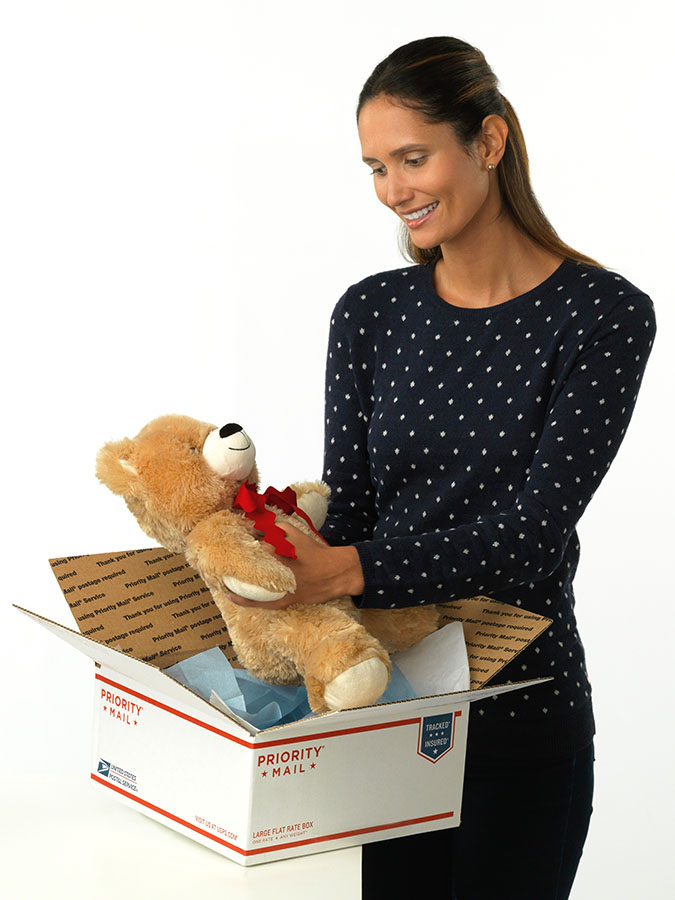 woman holding box with stuffed bear