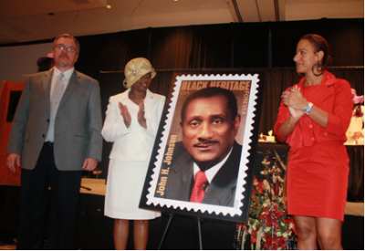 Fayetteville Postmaster Dean Fields, Delta Sigma Theta’s Fort Bragg Chapter President Sandra Collins and Ebony Editor-in-Chief Amy Dubois Barnett present John H. Johnson Black Heritage Stamp to guests at recent Big Hat Brunch.
