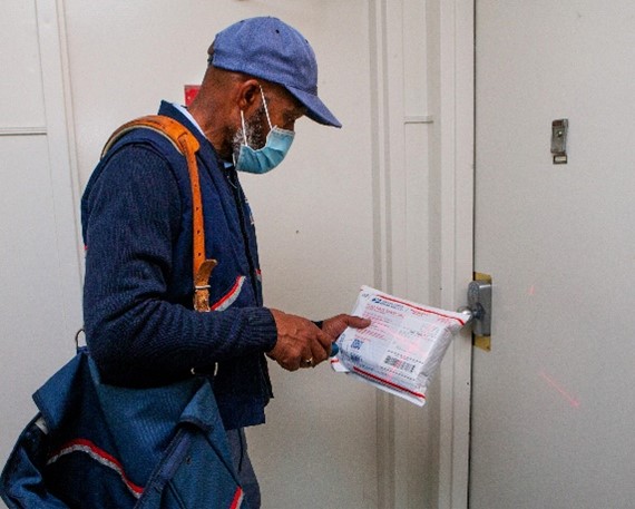 Masked Letter Carrier delivering a package