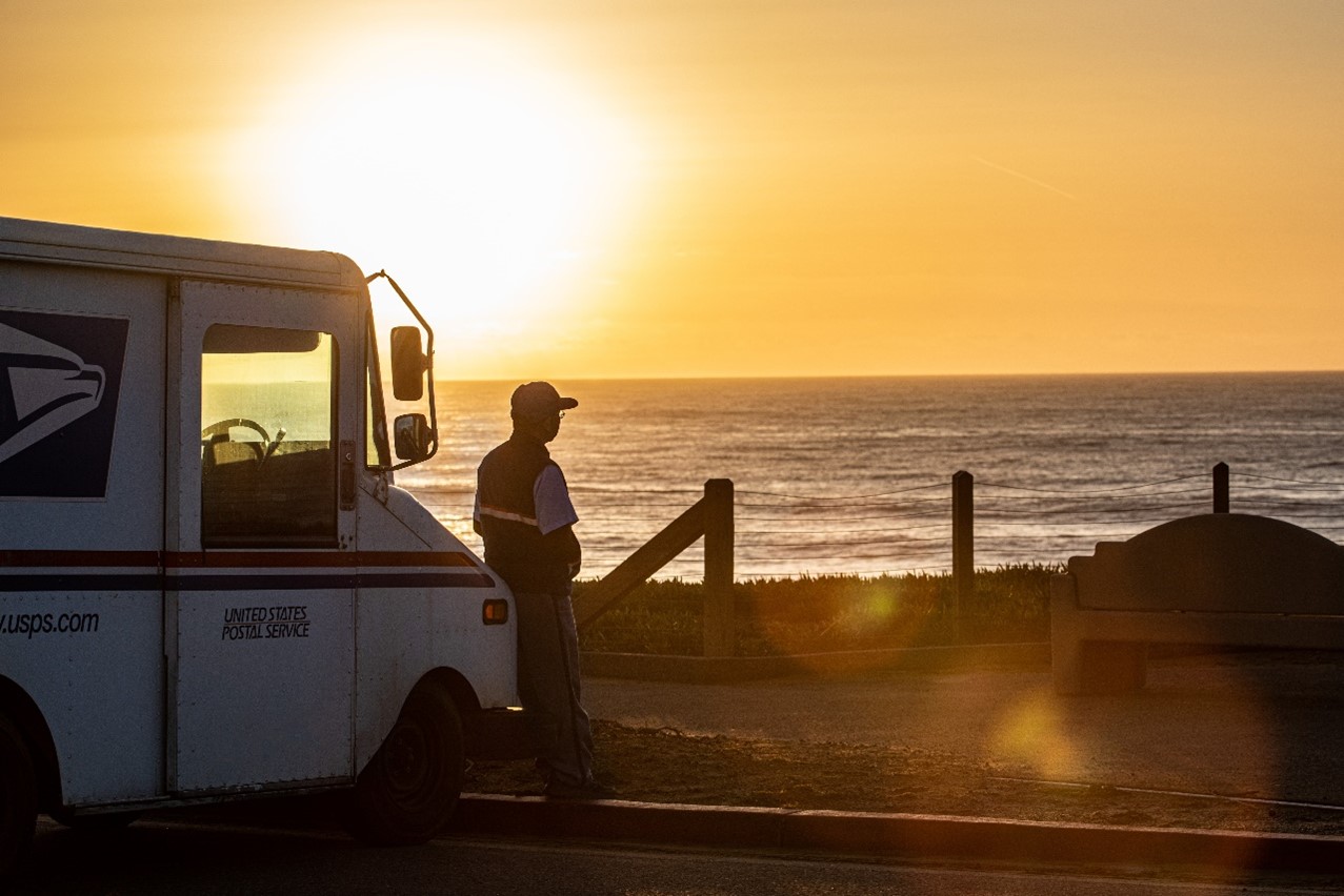 Postal Mail Carrier looking at the sunset