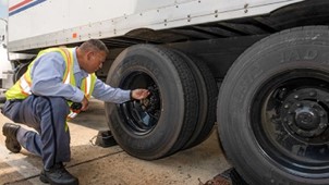 Vehicle operator checking tire.