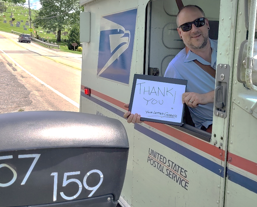 USPS Driver holding Thank You sign