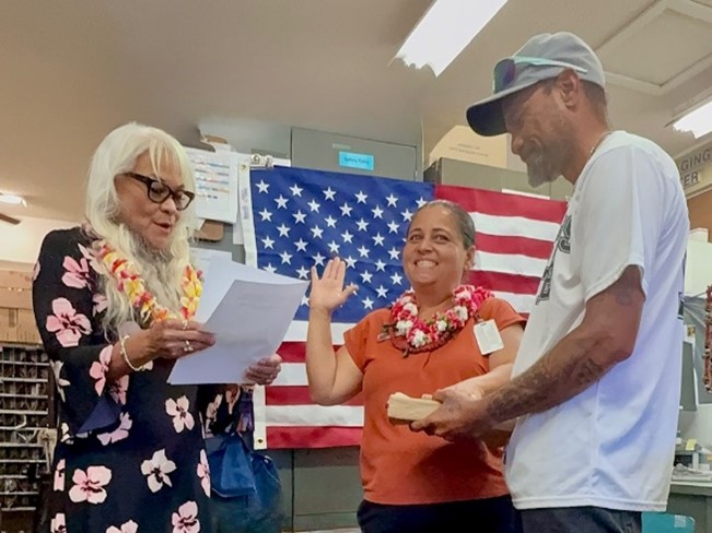 Hawaii District Manager Eileen Veach administers the of office to Anahola Postmaster Keleen Na-o (center) with her husband, Kawika Na-o, Sr. standing by her side. (USPS)
