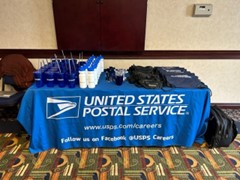 Table with USPS promotional items.