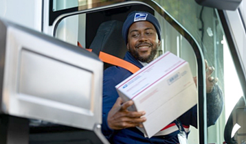 Male Rural Carrier delivering packages from vehicle.
