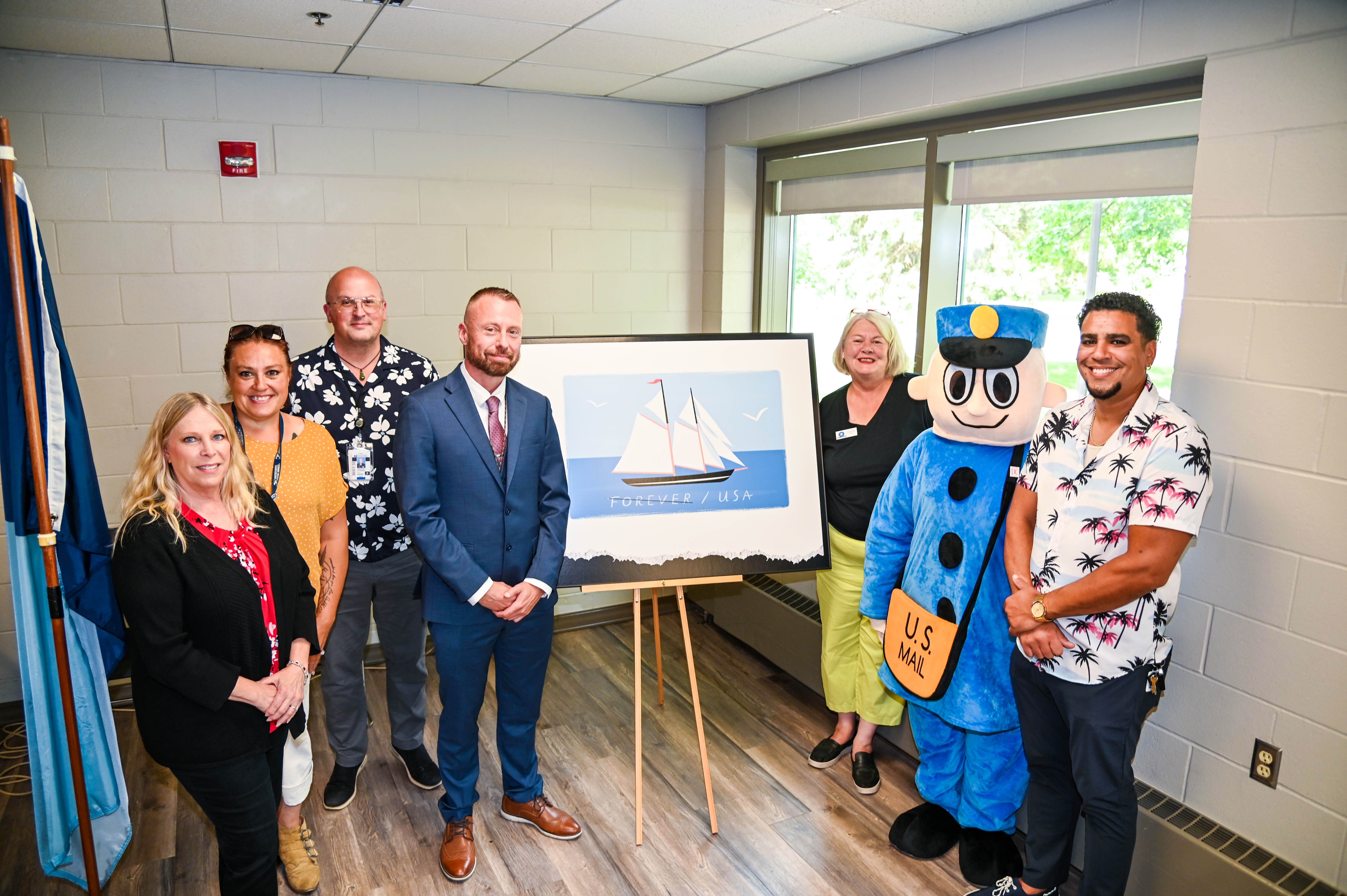 l-r, Administrative Assistant District Manager Office Michelle Schannauer, HQ Retail & Delivery Operations Command Center Sarah M. Schultz, MOI Secretary Abraham Peterson, Minneapolis Executive Postmaster Kenneth Johnson, City of Crystal, MN, Mayor Julie Deshler, Customer Relations Coordinator Cheryl Pendleton as Mr ZIP, and Manager Customer Services Luis Rosario