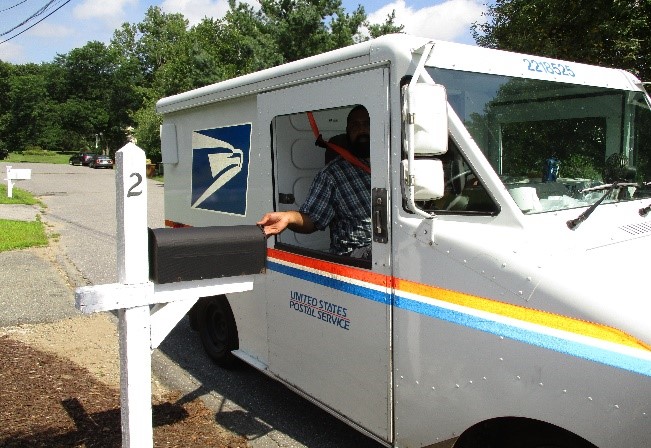 Mail Carrier delivering mail to residential mailbox
