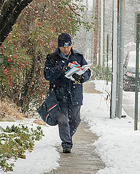 letter carrier delivering in the snow