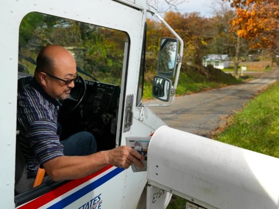 Rural carrier delivering mail and packages