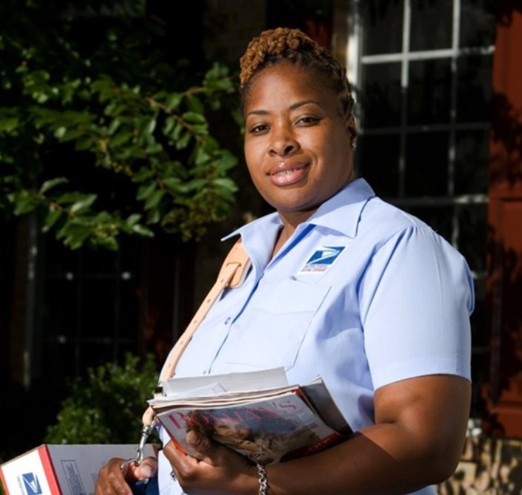 USPS Rural Carrier holding mail and packages.