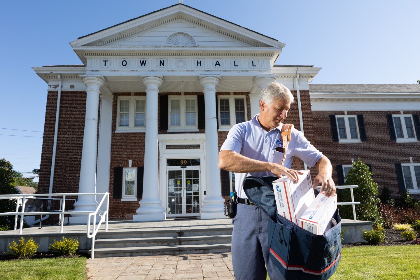 Letter Carrier in front of a Town Hall building