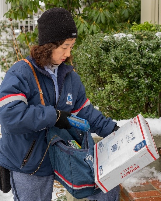 USPS Mail carrier scanning a package