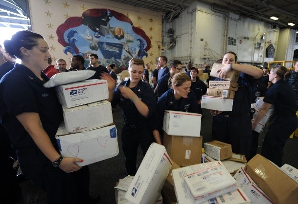 Sailors sort boxes during a mail call aboard USS Dwight D. Eisenhower in the Arabian Sea.