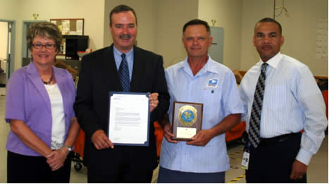 Customer Service Manager Karen Byers, District Manager Dave Fields and Postmaster Anthony Spriggs (r) congratulate City Carrier Danny Gray (c) on his Million Mile Award recognition.