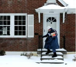 Mail person delivering mail during snow