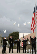 Postal employees release six white doves at a rememberance ceremony