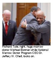 Richard Tate, right, hugs marrow donor Michael Bonner while National Marrow Donor Program CEO Dr. Jeffery W. Chell, looks on.