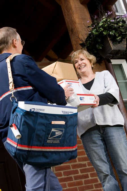 mail carrier delivering packages directly to a customer on a residential porch
