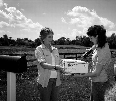 image of a customer receiving a priority mail flate rate box while a rural carrier scans the package