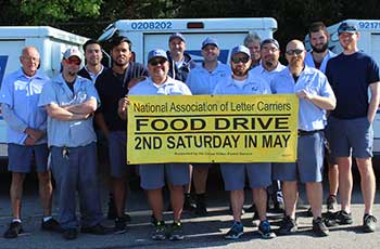 Employees holding food drive banner