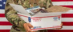 Military member holding a priority mail box