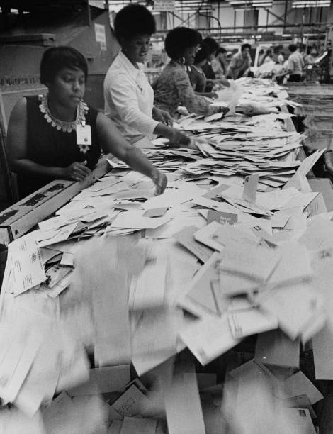 Photograph showing black women postal clerks sorting mail in the Chicago Post Office circa 1970.